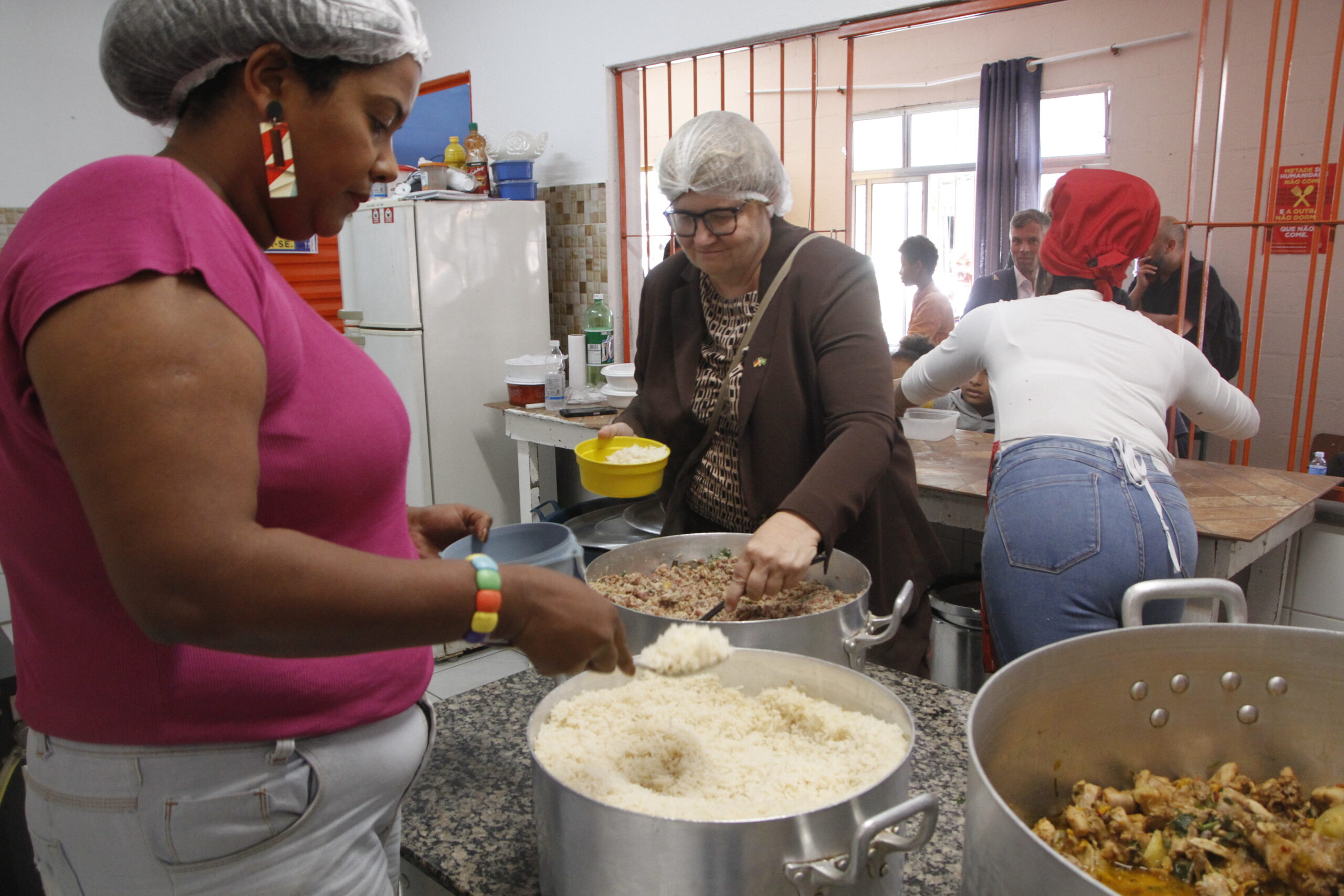 Vice-ministra do trabalho da Alemanha, Anette Kramme (centro) e Debora Lima, MTST (esquerda) ajudam a servir o alimento (Foto: Verena Glass)