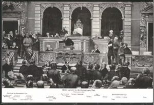 Um cartão postal de August Bebel falando com membros do Reichstag, em Berlim.